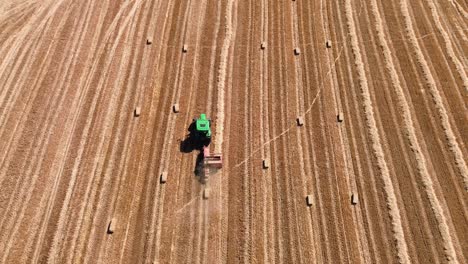 hay baler tractor on the field compressing automatic farm machine agriculture rural, aerial drone