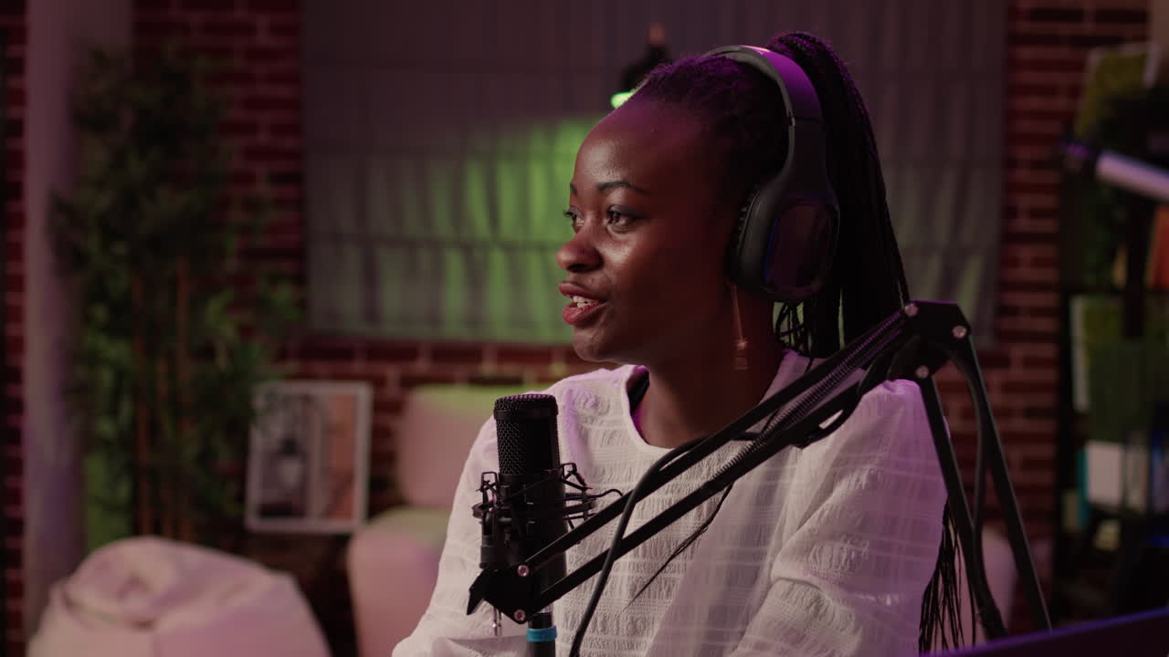 Closeup of african american online radio host recording podcast with male singer in late night interview