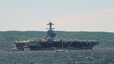 military ship uss gerald ford with boats sailing in oslo fjord in norway