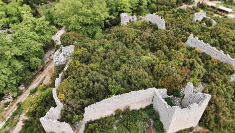 Vista-Aérea-De-Las-Ruinas-Del-Antiguo-Castillo-Romano-De-Kadrema-Ubicado-En-El-Pueblo-De-Gedelme-Y-La-Cresta-De-La-Montaña-Al-Fondo