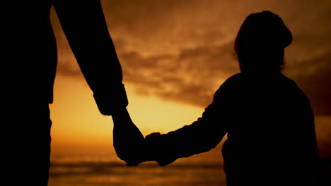 mother and child holding hands at sunset