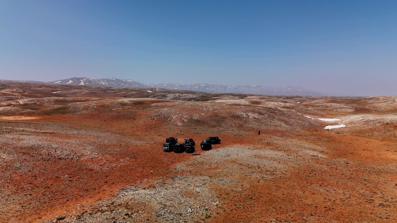 Aerial view of ATVs on rocky desert under clear blue sky