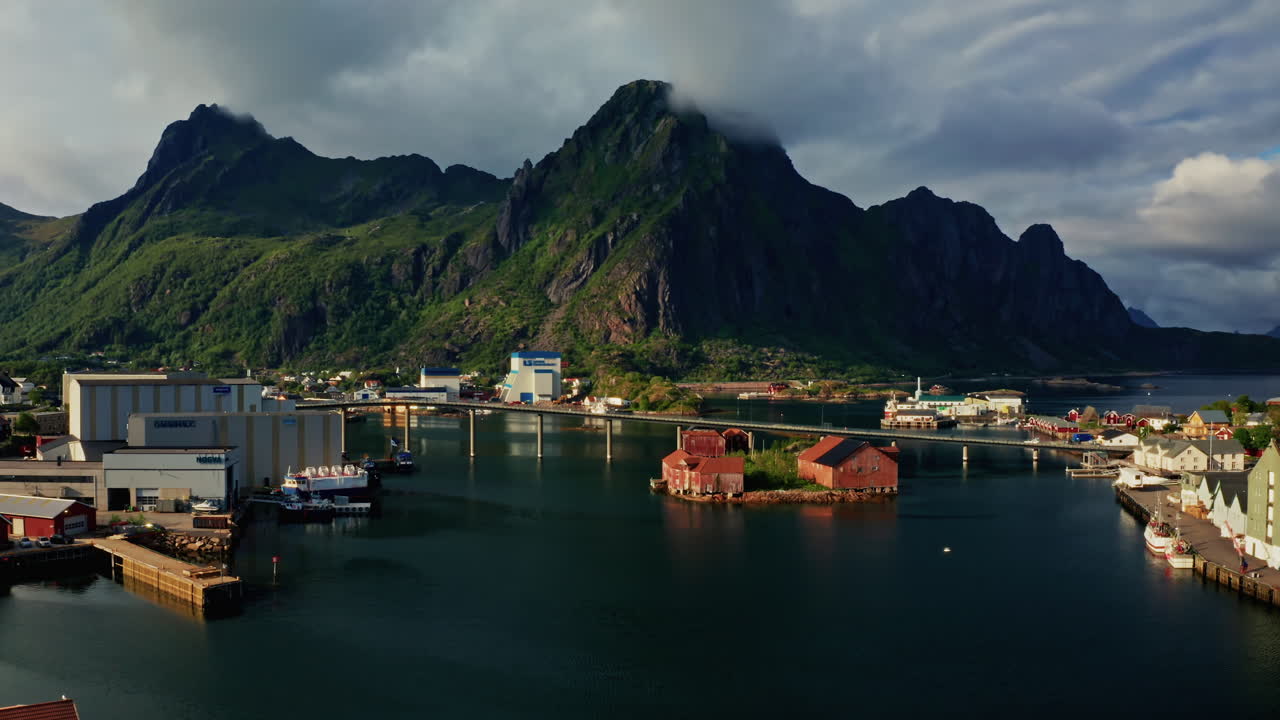 Aerial drone shot over Svolvaer, Lofoten Islands, Norway.
High view of the fishermen cabins and the scenic nordic landscape at sunset.