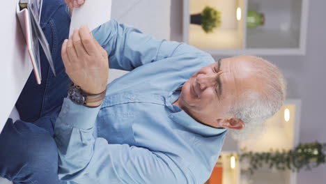 Vertical-video-of-The-old-man-who-loves-the-photo-in-his-hand.