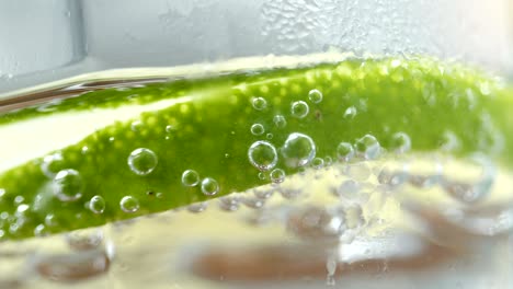 macro close up slice lemon, ice cubes and bubble float soda water.