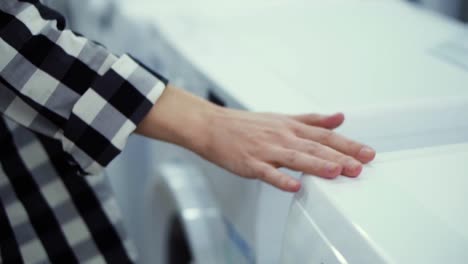 Choosing-washing-machine-in-appliance-store.-Running-hand-by-the-row.-Unrecognizable-woman-in-household-appliances-department