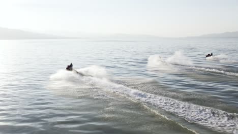 three riders racing jet ski waverunners on utah lake, aerial with copy space