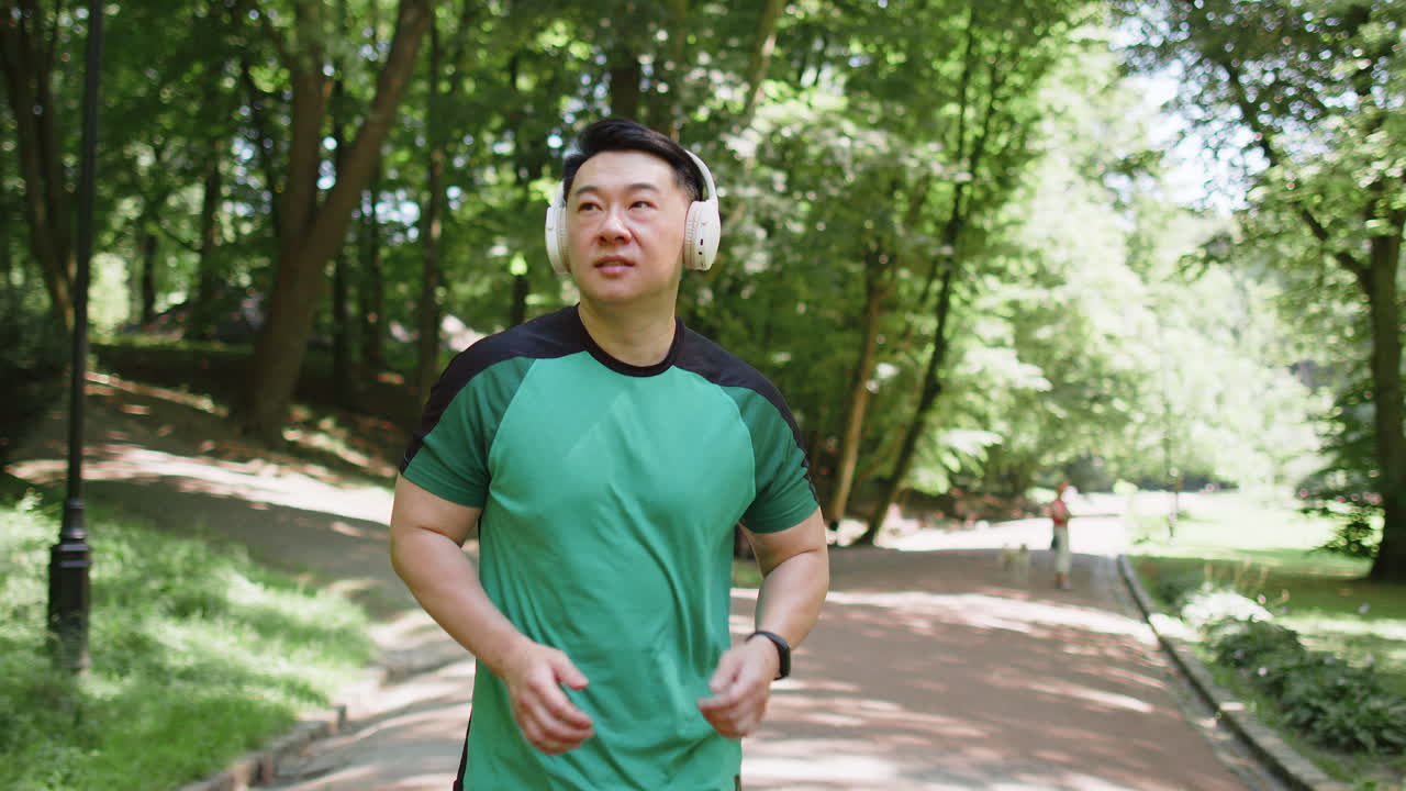 운동선수 조 훈련 마라톤 달리기 공원에서 무선 헤드폰으로 음악을 듣는