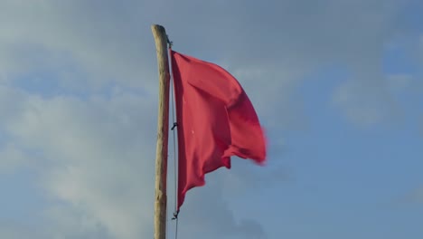 danger - red no swimming flag posted along the shore of mexico beach warning people not to swim in the area