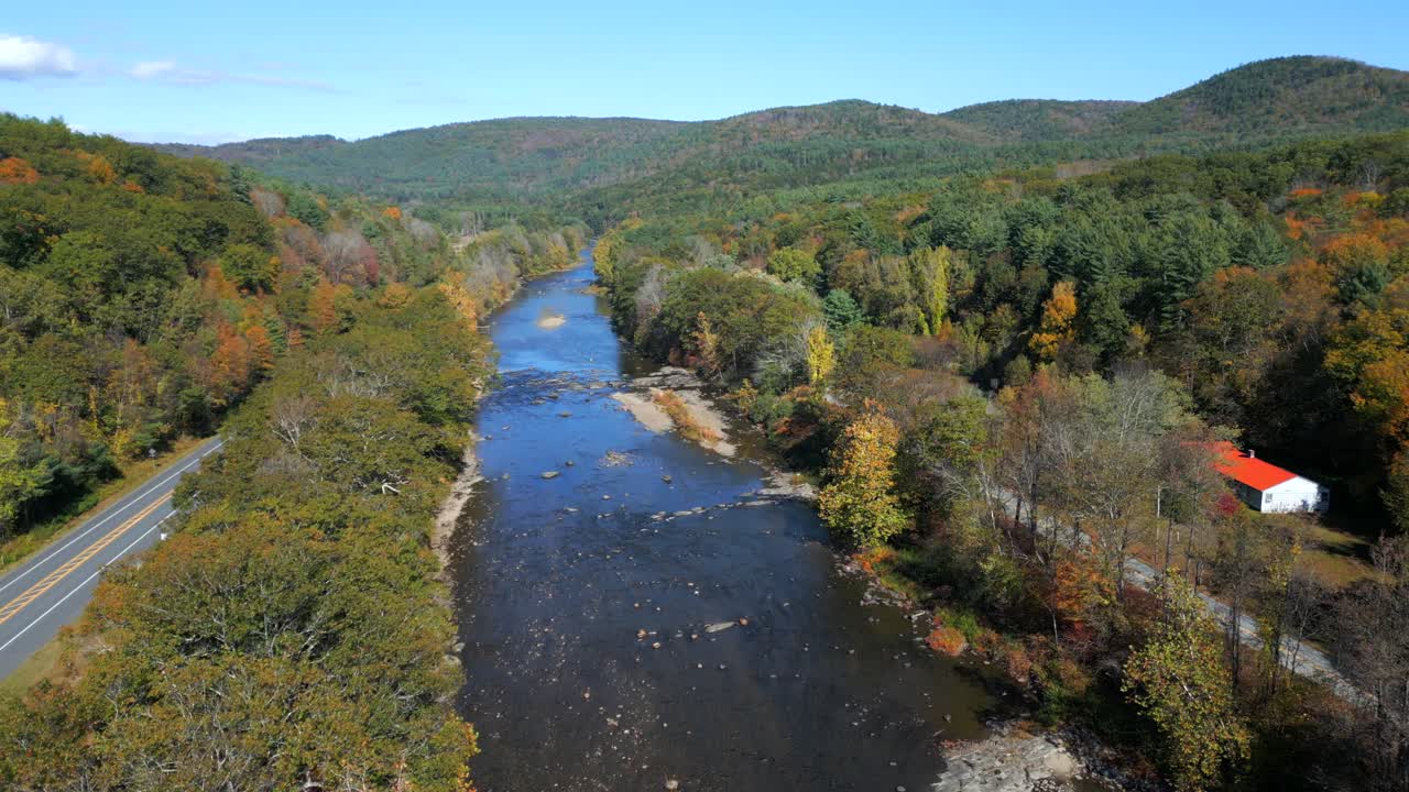 Cars cross by along road along West River, Green Mountains Vermont USA