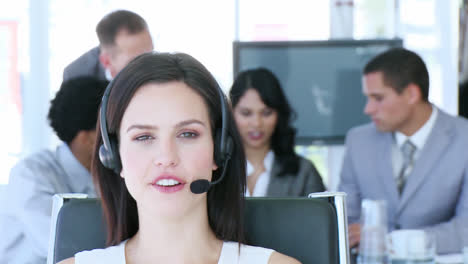 retrato de una mujer de negocios hablando en un auricular frente a su equipo