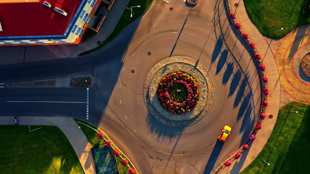Top view of flower roundabout with yellow car in Valmiera, Latvia on golden hour