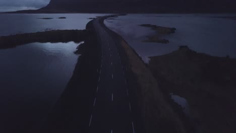 drone shot in the westfjords of iceland flying along a street into the landscape