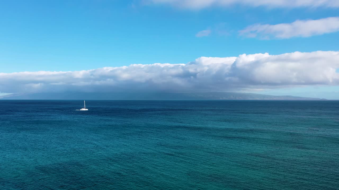 catamaran sailboat sailing off the coast of an island