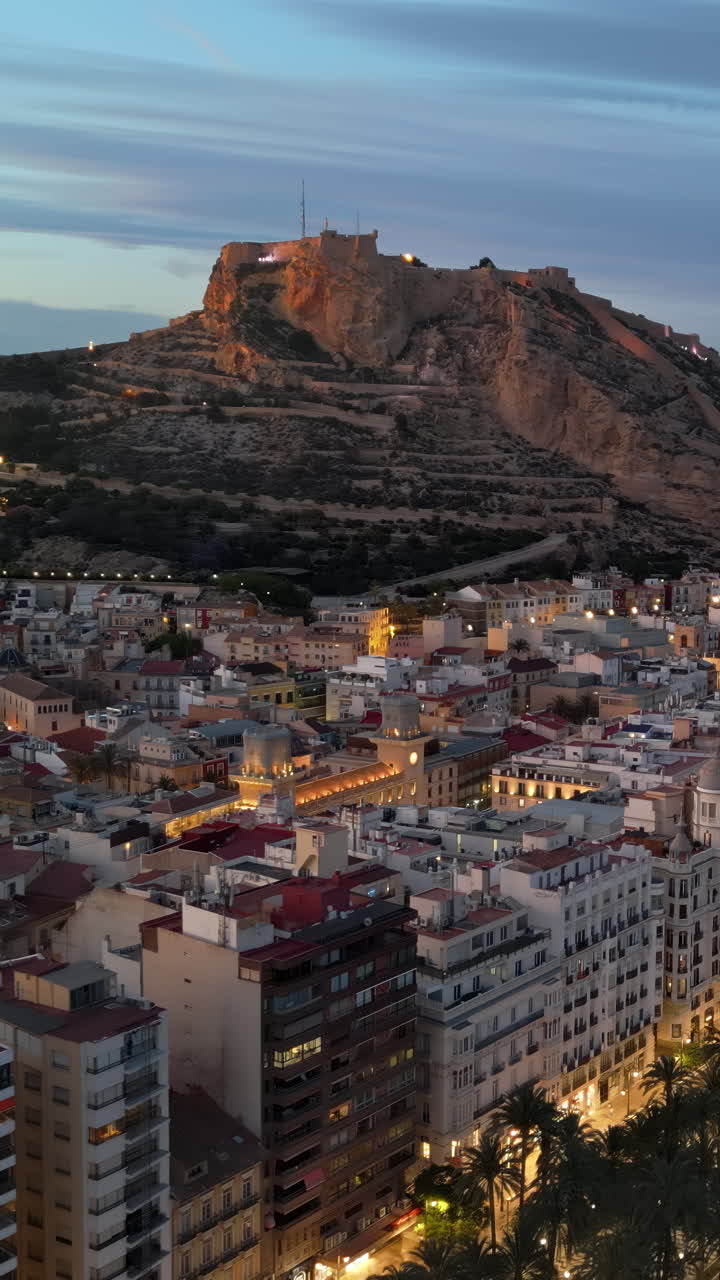 Aerial drone view of the Santa Barbara Castle on the coast of Alicante, Spain at sunset. Vertical
