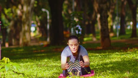 Sporty-middle-aged-woman-working-out-laying-on-red-rubber-mat