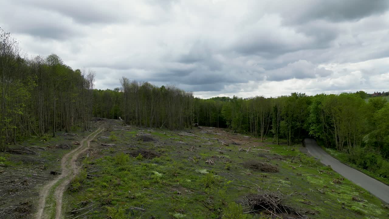 Slow drone footage over deforestation with low dark clouds