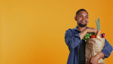 hombre afroamericano presentando una manzana verde recién cosechada