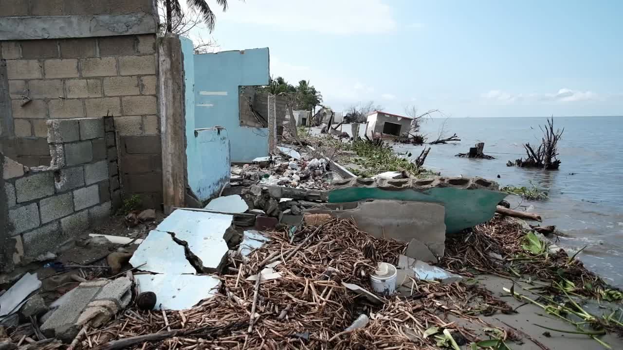 Litorale della spiaggia con diverse case distrutte, colpite dall'innalzamento del livello del mare a causa del cambiamento climatico
