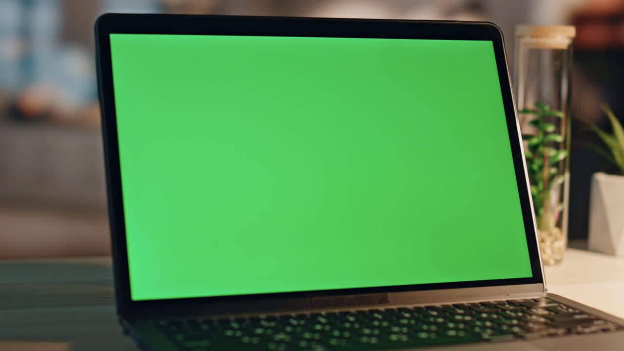 freelancer tocca il touchpad del portatile chromakey con il dito durante il primo piano notturno dell'ufficio