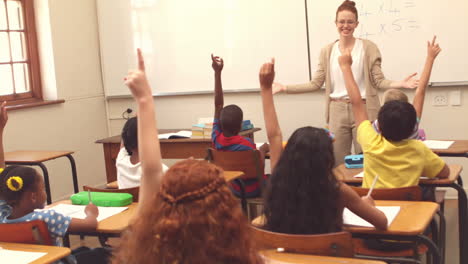 cute pupils raising hand in classroom