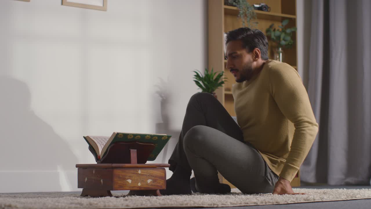 Muslim Man At Home Sitting And Reciting From The Quran