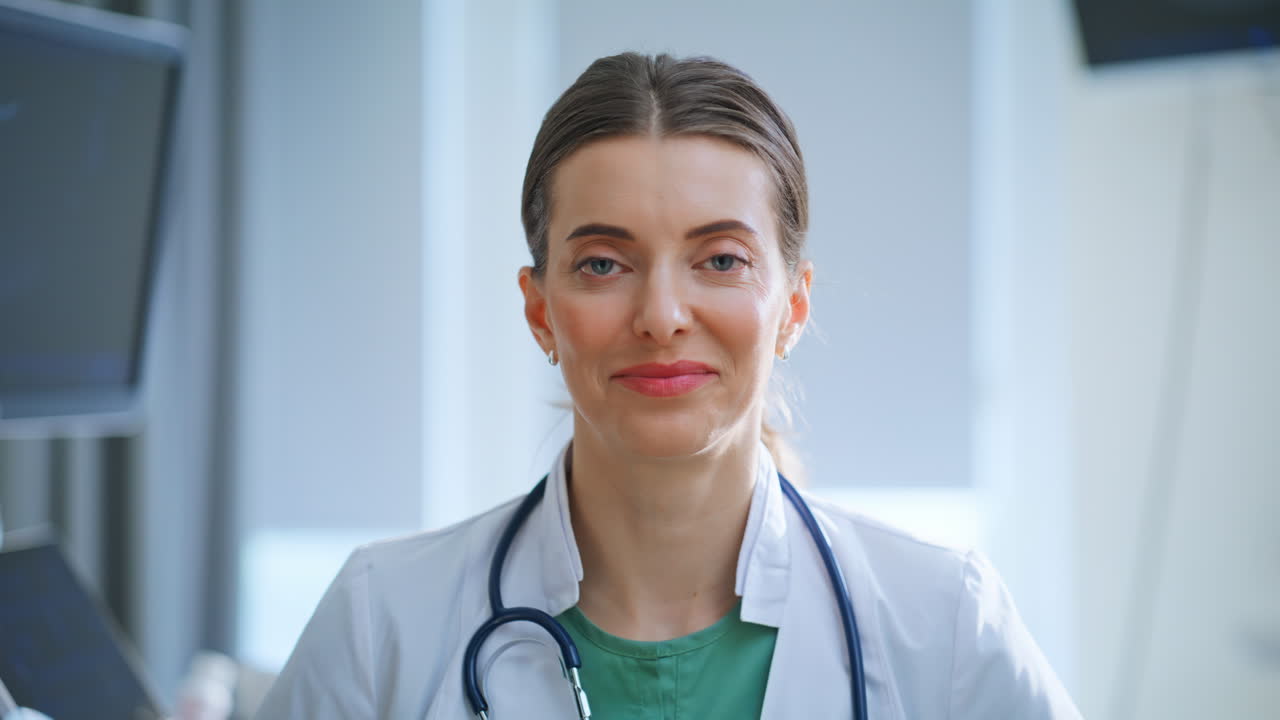 Retrato de uma médica sorrindo sentada no saguão de um consultório.