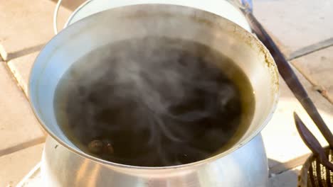 steam rising from a boiling pot outdoors