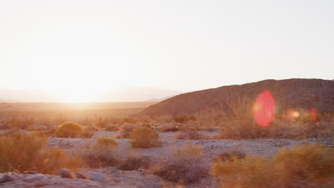 view of desert landscape from moving vehicle