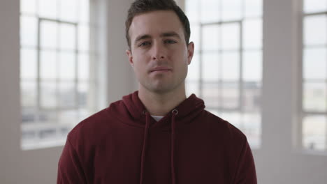 Primer-Plano-Retrato-De-Un-Joven-Y-Apuesto-Hombre-Caucásico-Que-Parece-Enfocado-Y-Serio-Ante-La-Cámara,-Un-Hombre-Intenso-Mirando-En-Un-Moderno-Apartamento-Con-Capucha