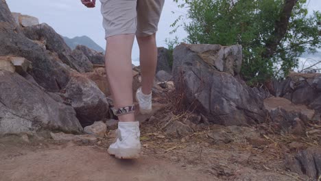 close up of male hiker's legs hiking to the top foggy mountain