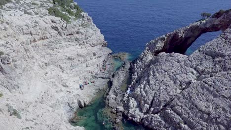 drone footage of korakonissi inlet, featuring blue seas, rock formations and grotto