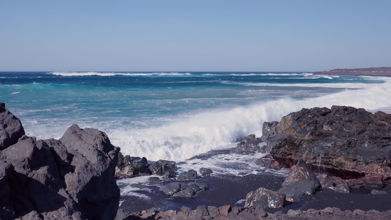 fuertes olas chocando contra las rocas volcánicas