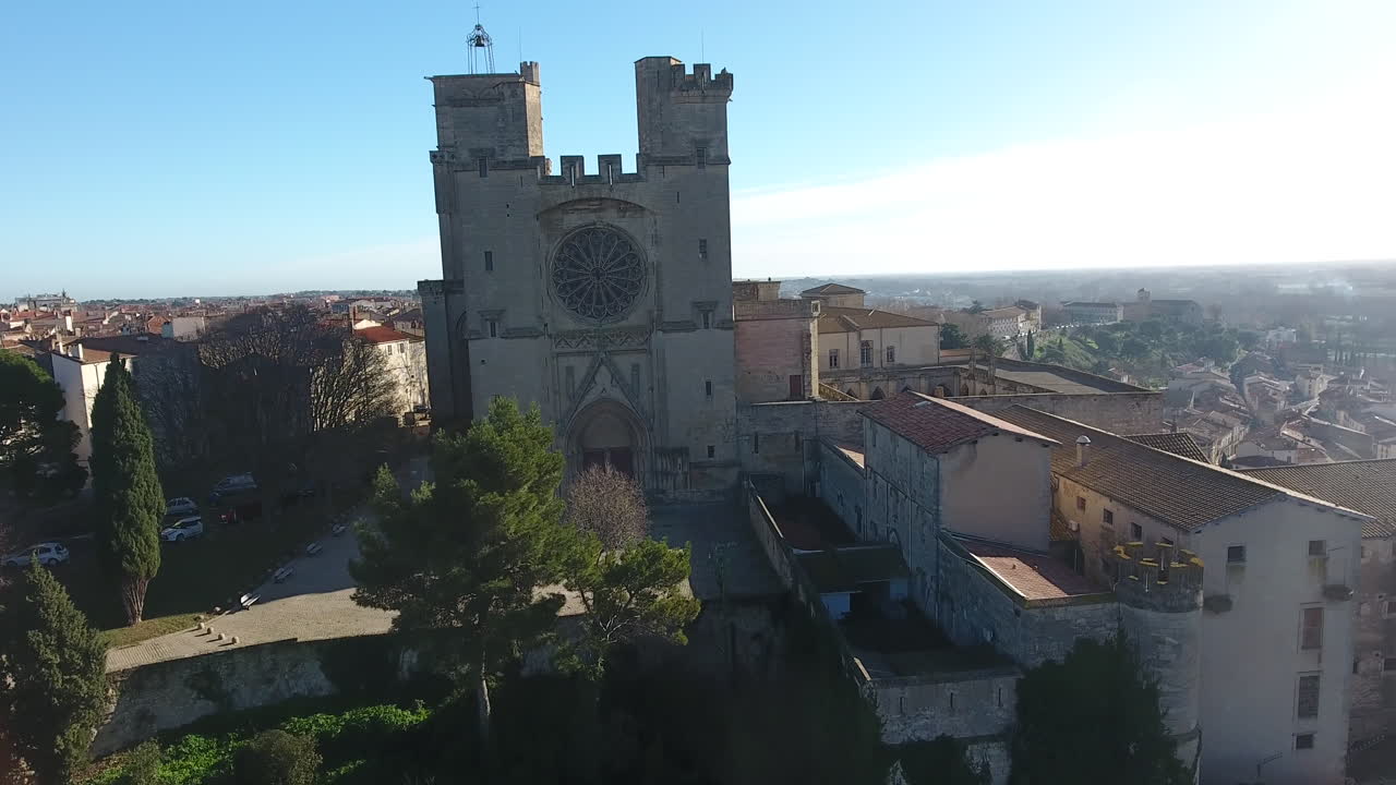 pista aérea de drones hacia la catedral de béziers día soleado