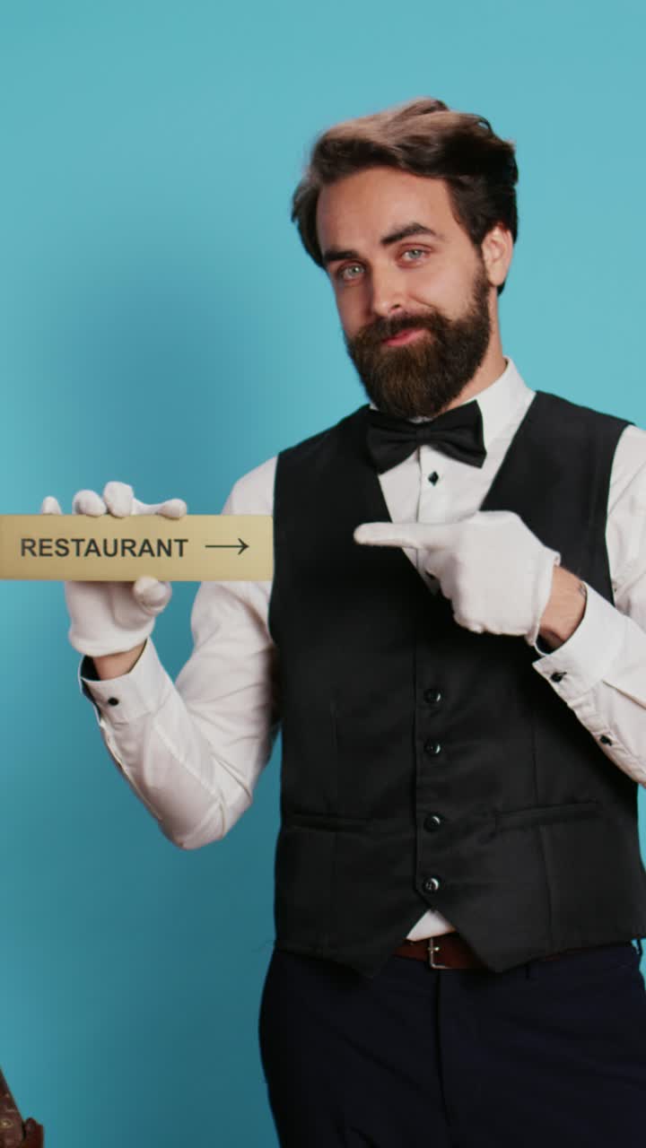 Video verticale: un facchino d'albergo pubblicizza l'insegna di un ristorante