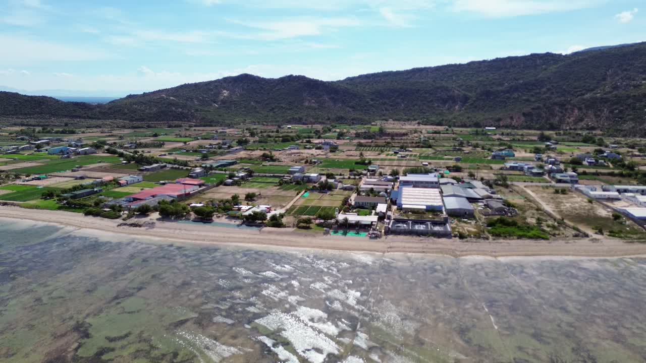 Aerial view of My Hoa Lagoon in Phan Rang, Vietnam, featuring a dramatic zoom in towards the shoreline and surrounding nature. My Hoa Vietnam, famous kitesurfing spot during low season.