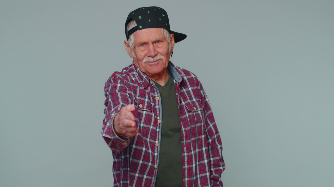 hombre amistoso extendiendo la mano a la cámara, ofreciendo un apretón de mano, saludando con una sonrisa amable, bienvenido