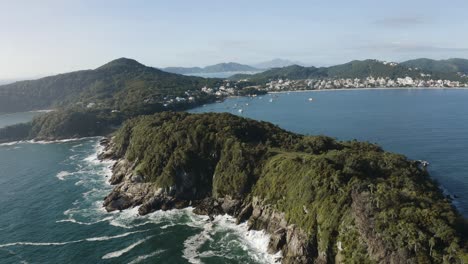 toma cinematográfica épica con drones que distancia una paradisíaca costa brasileña con grandes olas, altos acantilados, jungla y aguas azules profundas.