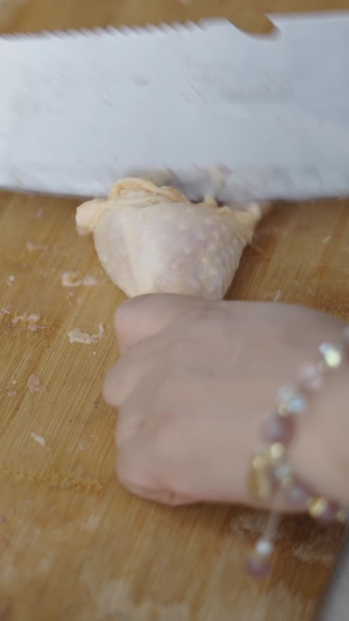 Cutting chicken on a wooden board