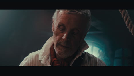 an old captain sits writes a letter inside the sailing ship cabin