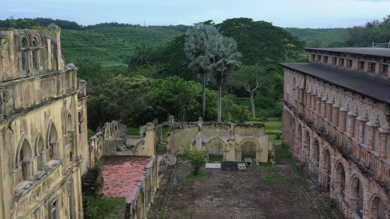 drone vuela sobre el patio capturando ruinas coloniales británicas, estructura de arquitectura incompleta a orillas del río antigua locura escocesa, castillo de kellie en batu gajah, distrito de kinta, perak, malasia