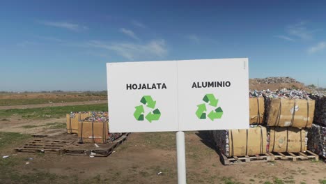 signs mark bales of compacted tin and aluminum at a waste processing facility