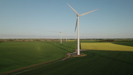 Drone-Girando-Alrededor-De-Una-Enorme-Turbina-De-Energía-Eólica-En-Un-Campo-Agrícola-Sueco