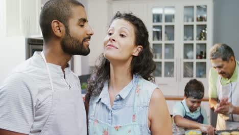 Couple-kissing-while-family-preparing-cookies-in-background-4K-4k