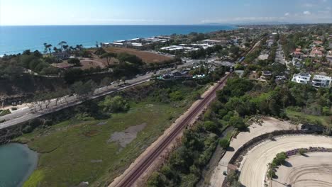 Aerial-drone-footage-of-train-passing-Del-Mar-racetrack-in-the-San-Diego