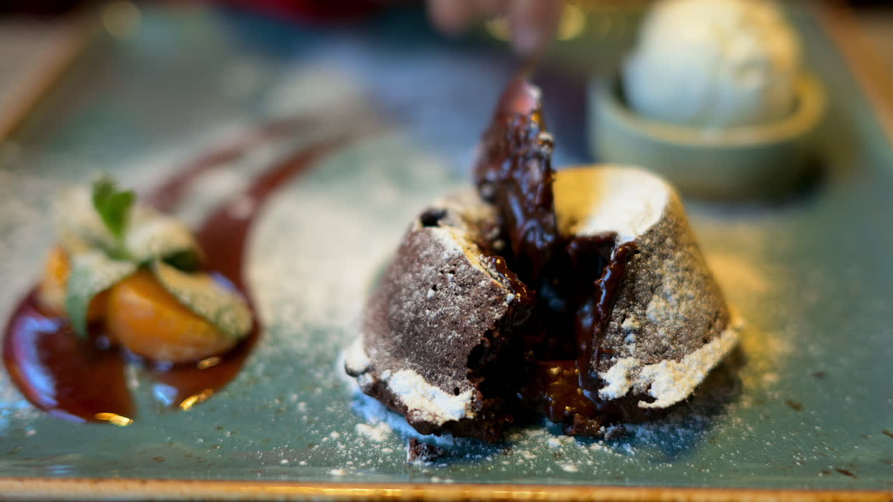 Chocolate lava cake with ice cream and orange decoration in a restaurant