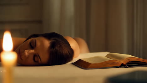 woman relaxing with a book by candlelight