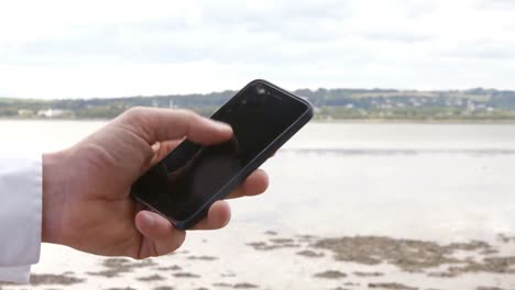 primer plano del hombre usando su teléfono inteligente