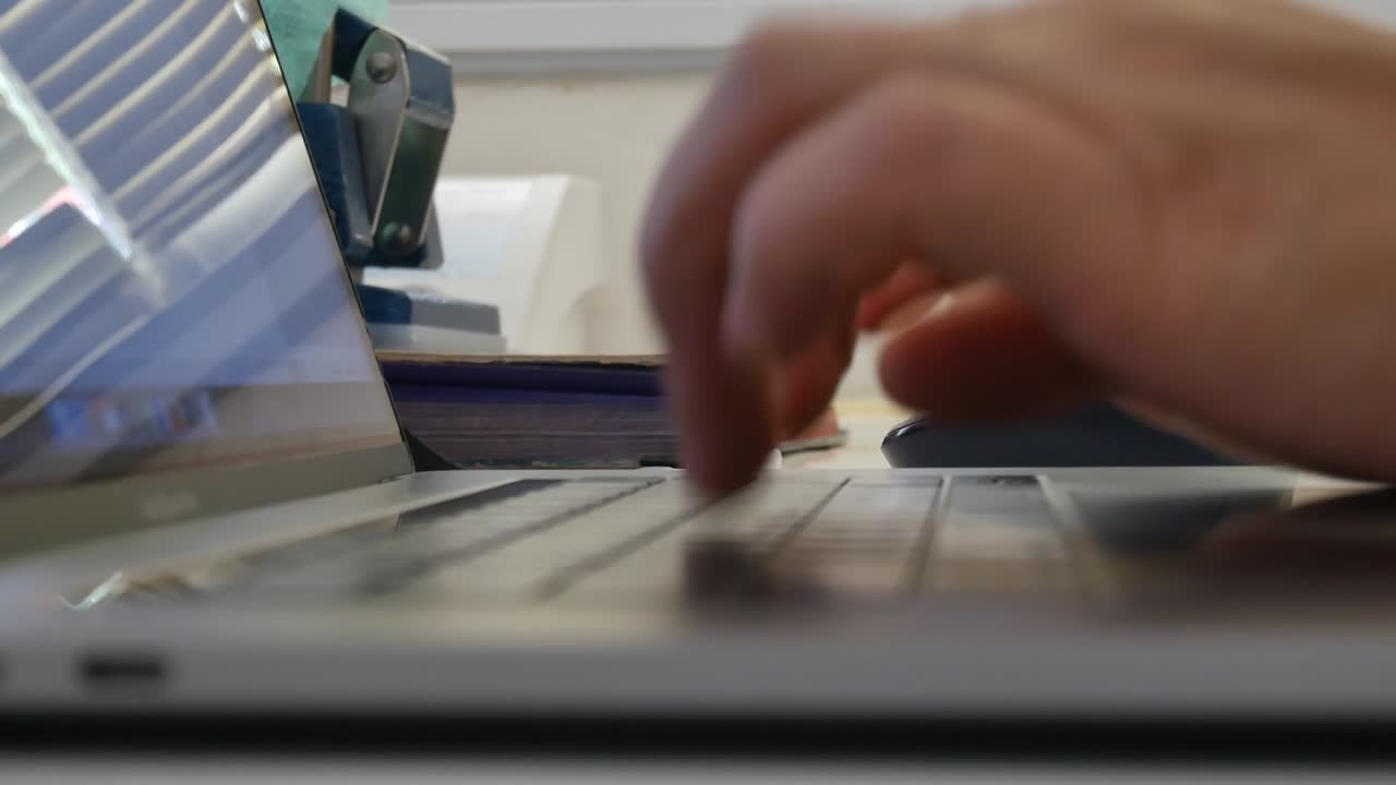 las manos de una mujer de negocios trabajando y escribiendo en una computadora portátil.