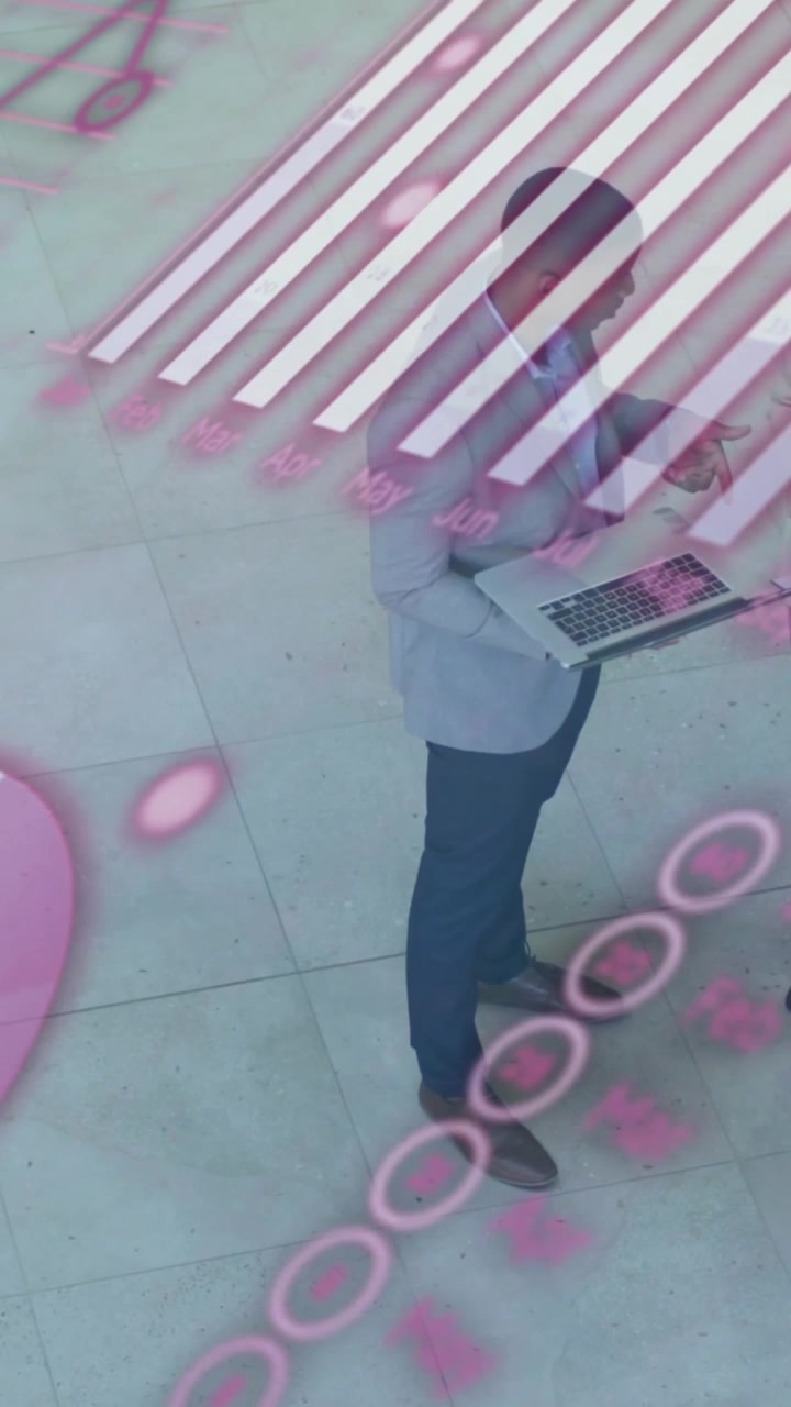 Animazione di un grafico, un globo e codice informatico, colleghi di diverse etnie che discutono rapporti su un laptop